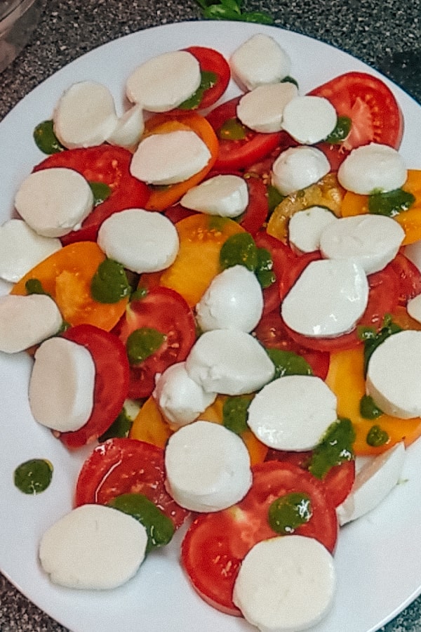 Yellow and red tomatoes with mozzarella and basil pesto