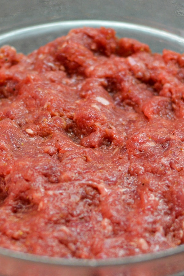 Mixed ground beef meat with salt, pepper and mustard.