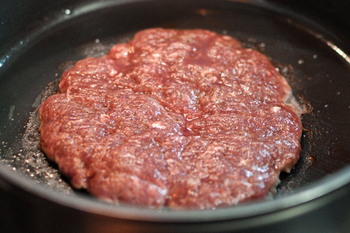 Cooking a burger on a pan.