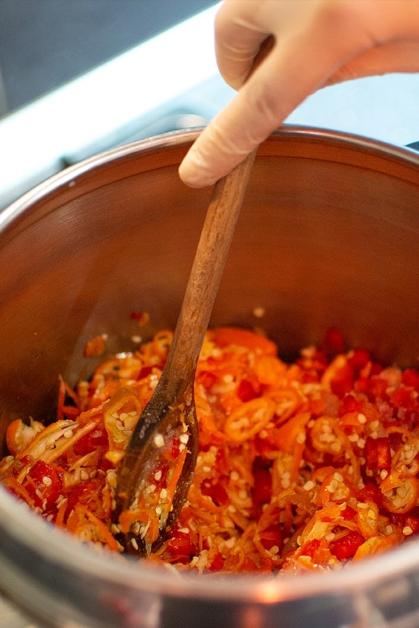 Mixing sliced chili peppers.