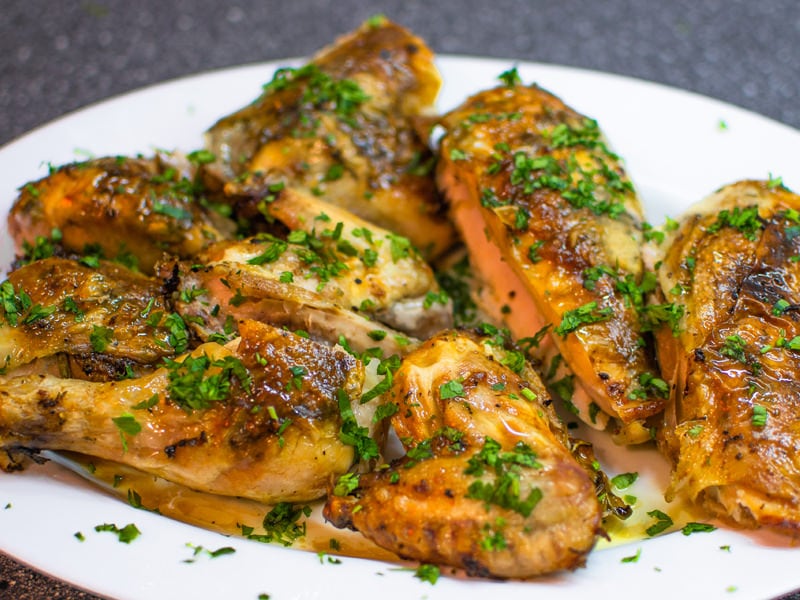 Golden roasted chicken with herbs on it.
