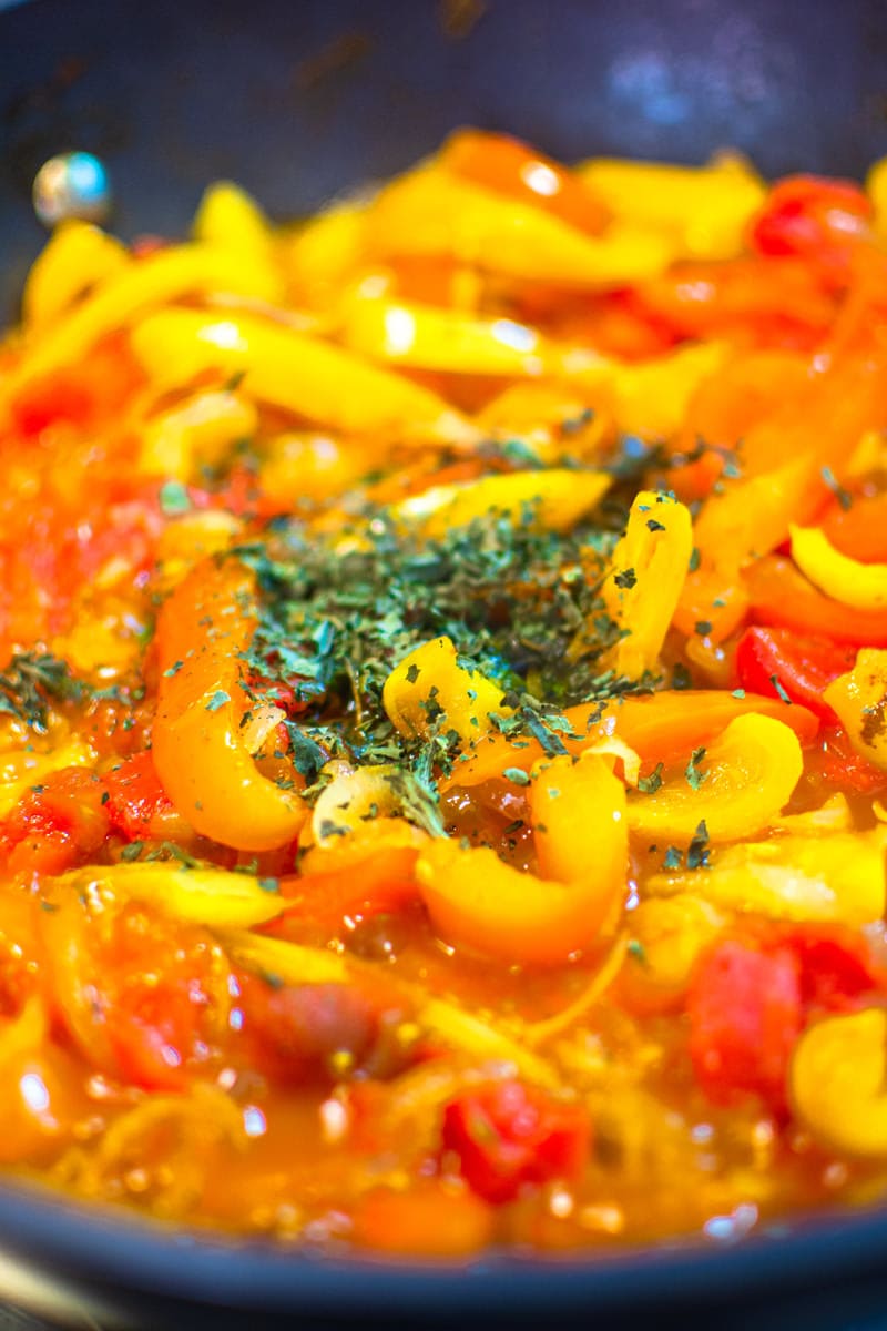 Adding aromatic herbs over bell peppers