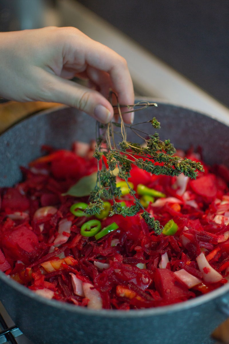 Adding aromatic herbs into an Ukrainian borscht