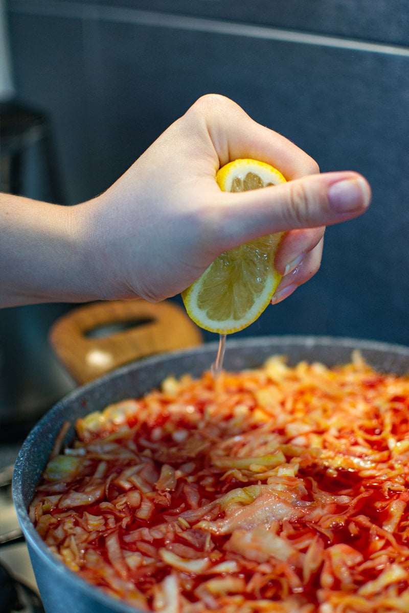 Adding a lemon juice into a red Ukrainian Borscht