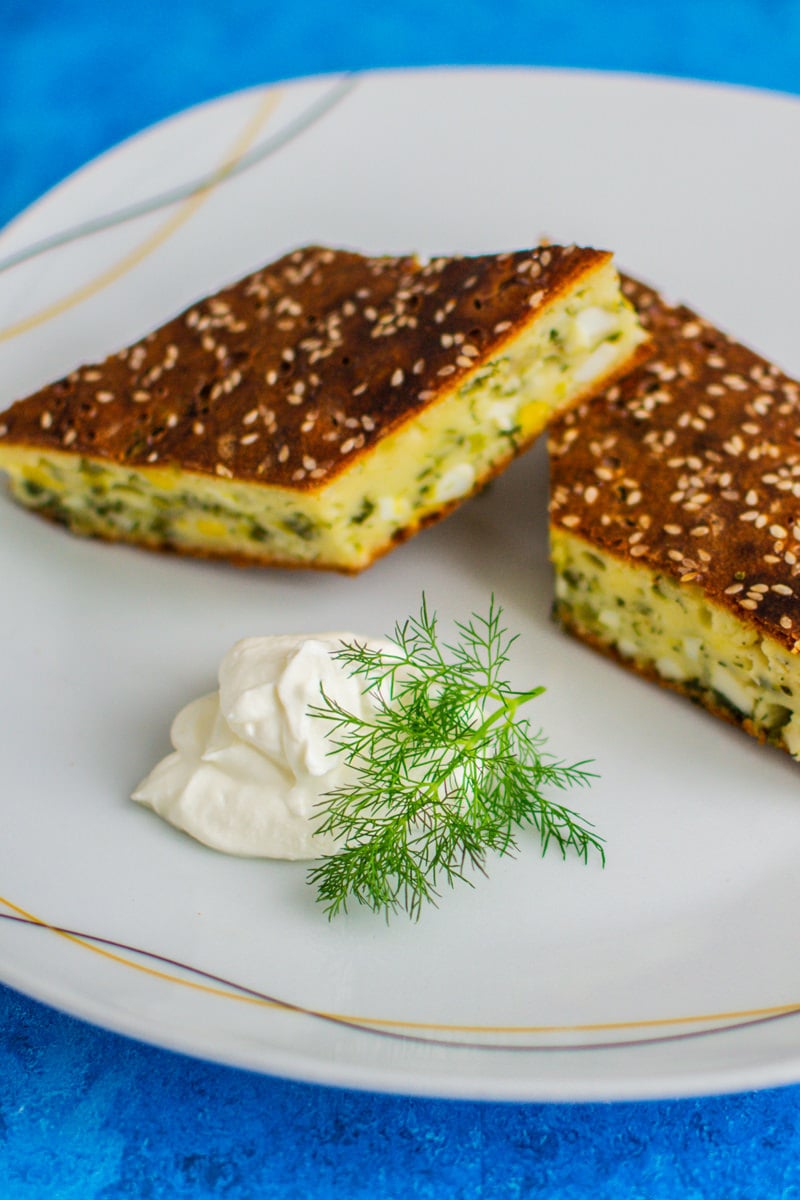 Two slices of spring onion egg tart with sour cream and dill.