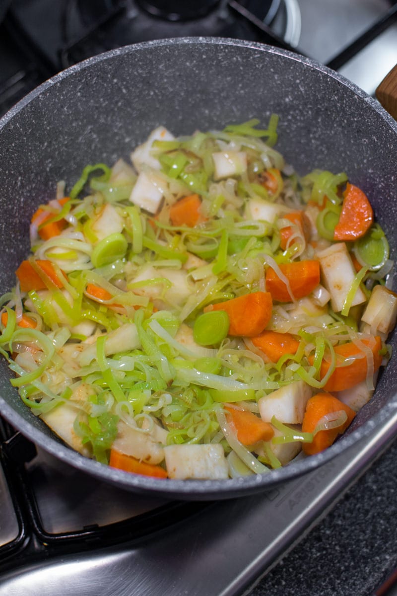Boiling leek and celery roots for a creamy soup.