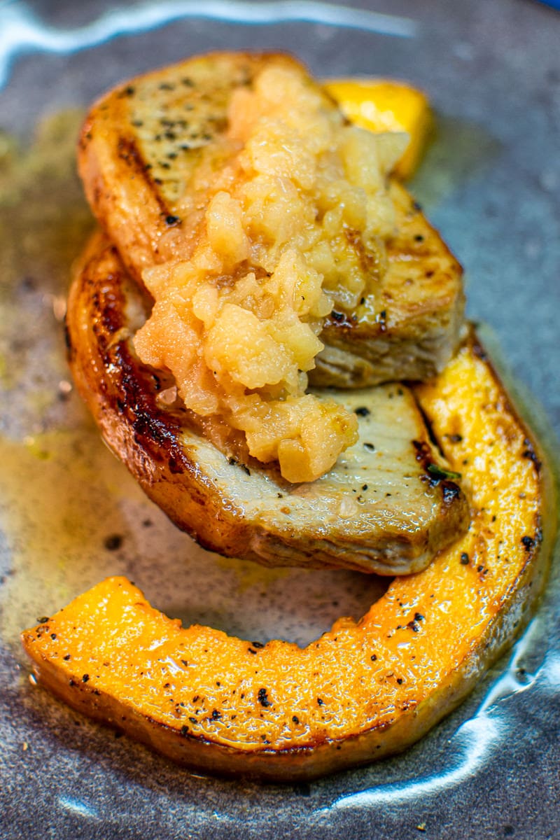 Delicious looking Boneless pork chops with quince jam and fried pumpkin.