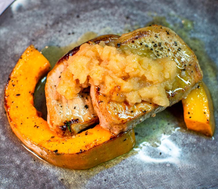 Delicious looking Boneless pork chops with quince jam and fried pumpkin.