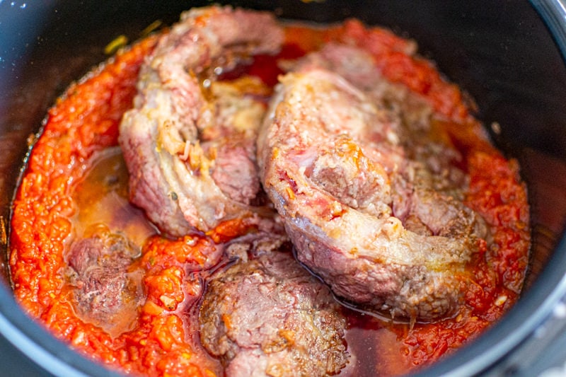 Three pieces of veal shanks with tomato sauce.