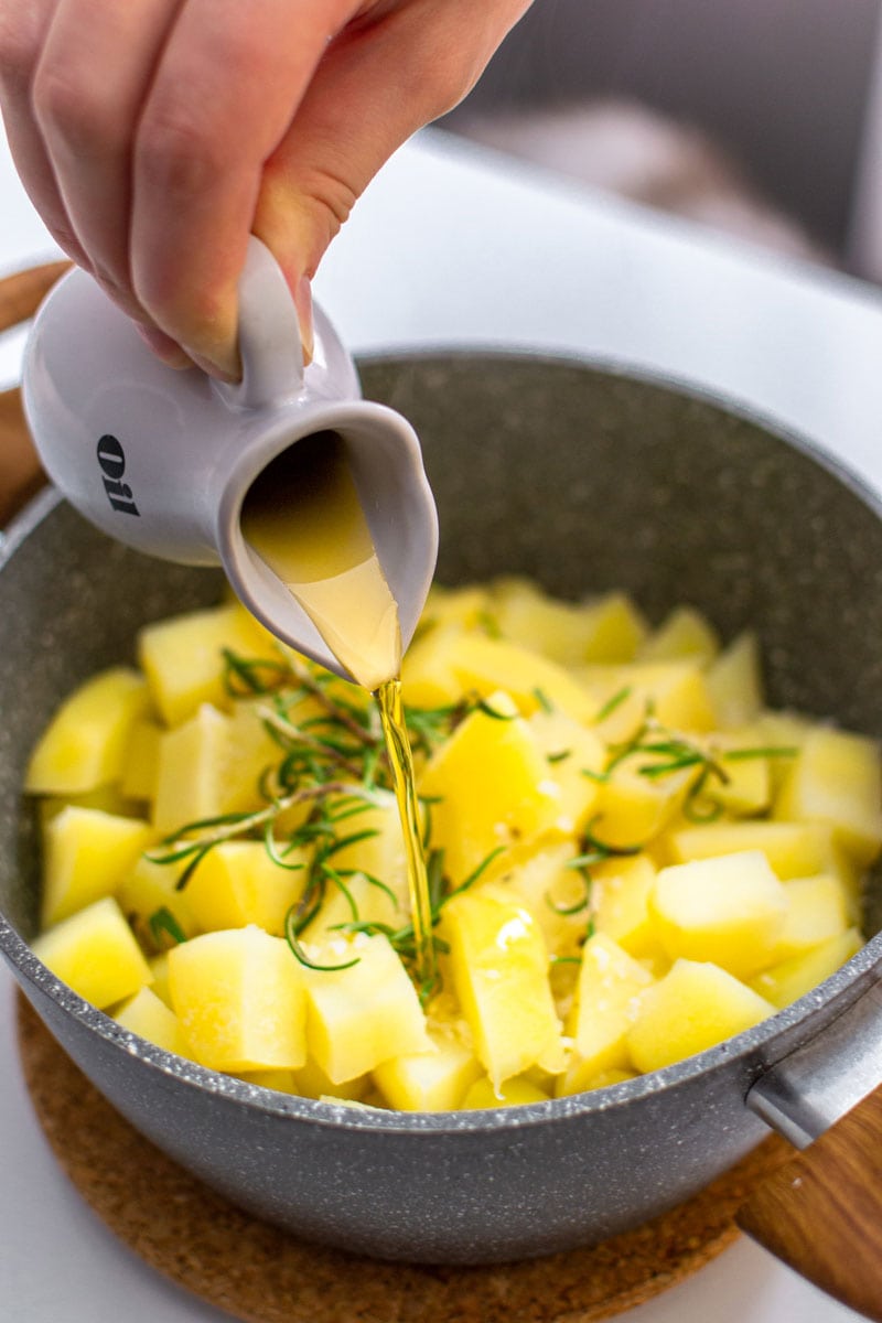 Pouring olive oil above the Parmentier Potatoes.