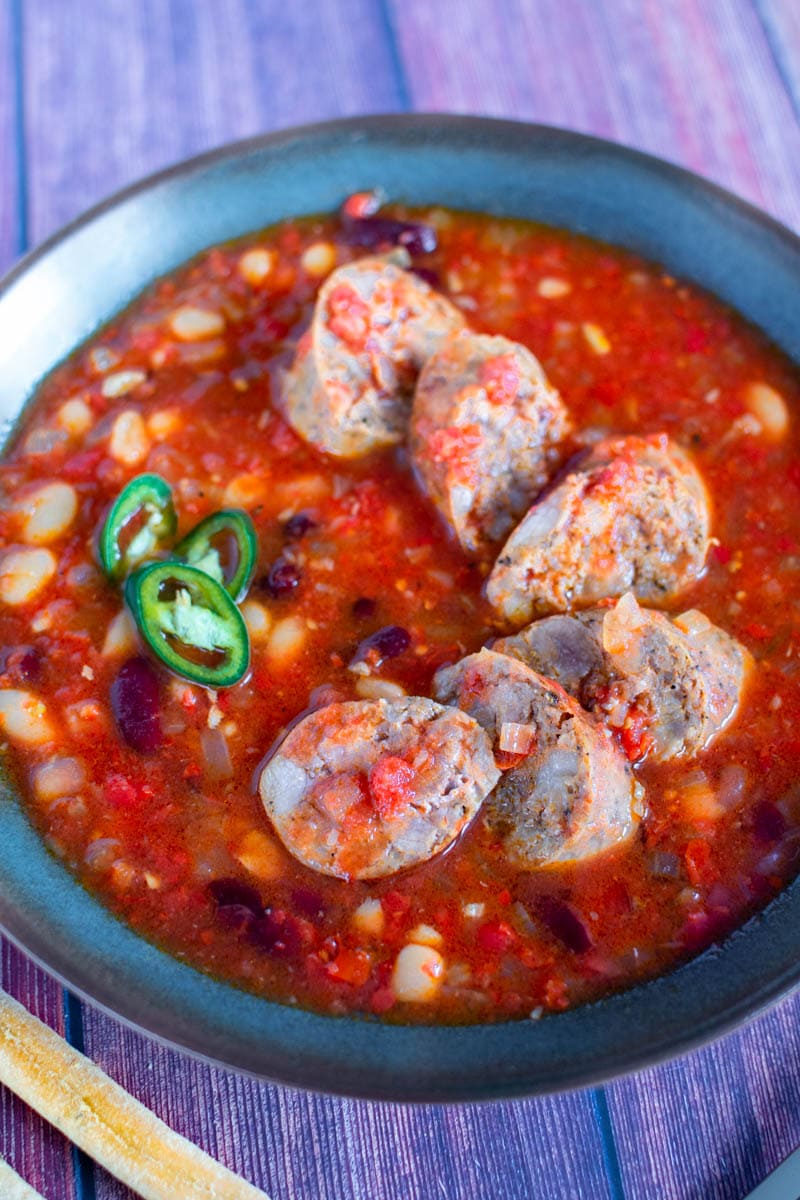 Slices of Sicilian sausages with beans in a tomato sauce.
