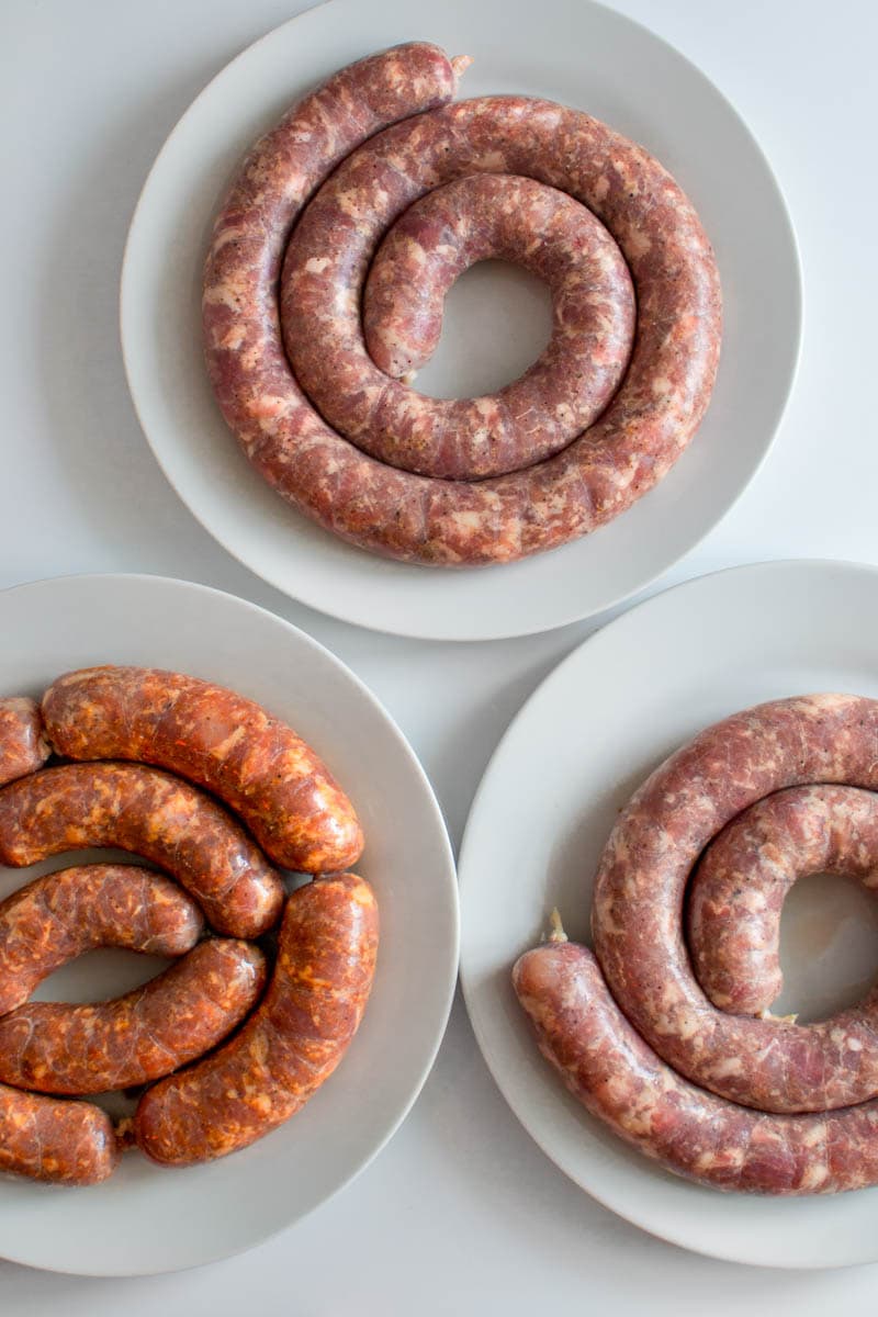 3 types of Sicilian sausages in white plates.