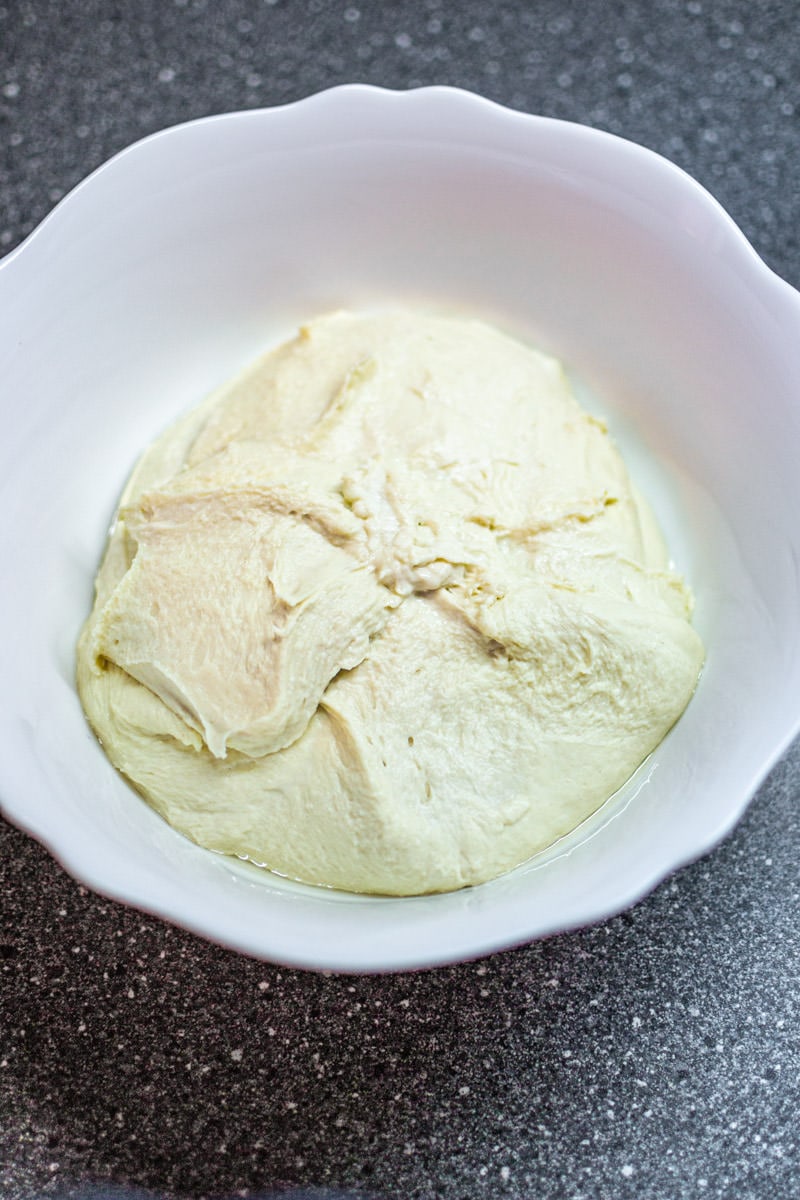 Focaccia dough in a white plate.