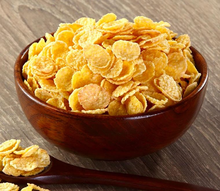 Cereal corn flakes in a wooden plate on the table.