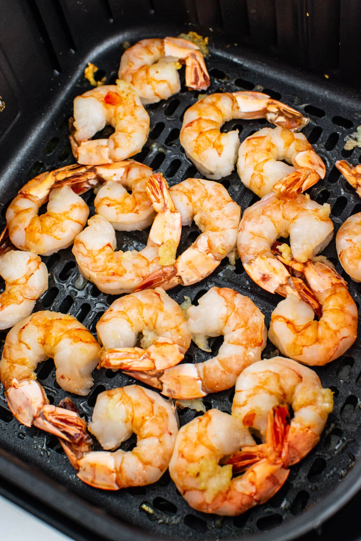 Close look at cooked shrimps in the Cosori air fryer basket.