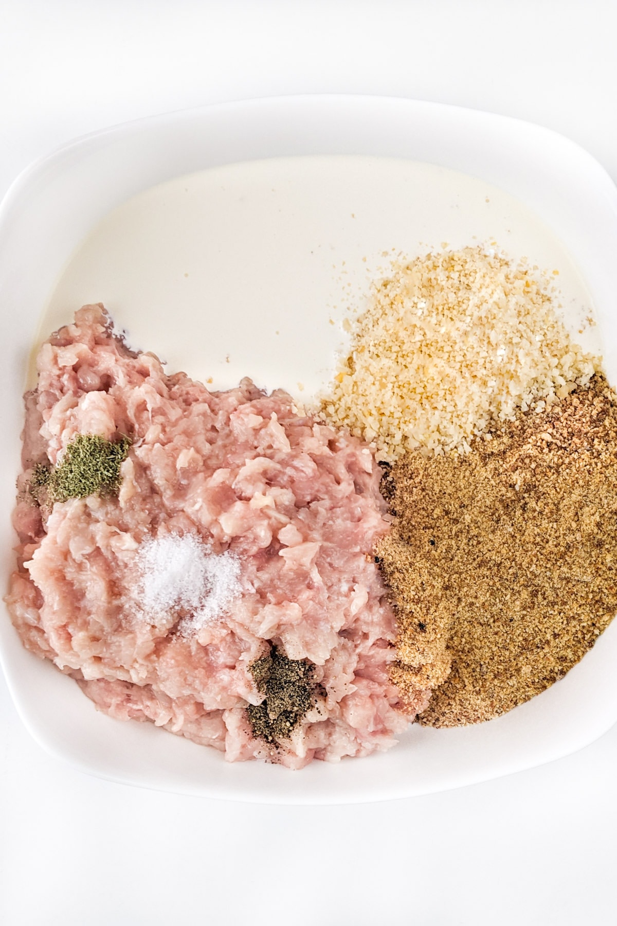 Plate with ground chicken meat, breadcrumbs, parmesan and whipped cream.
