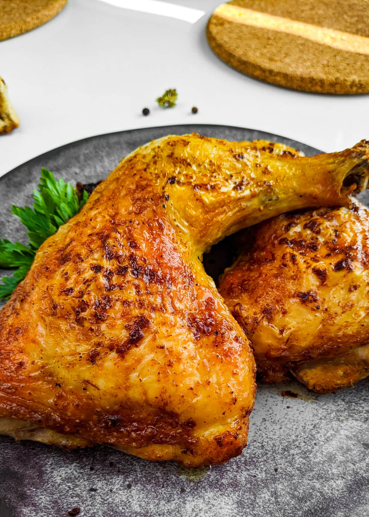 Close look of roasted chicken legs on a gray plate.