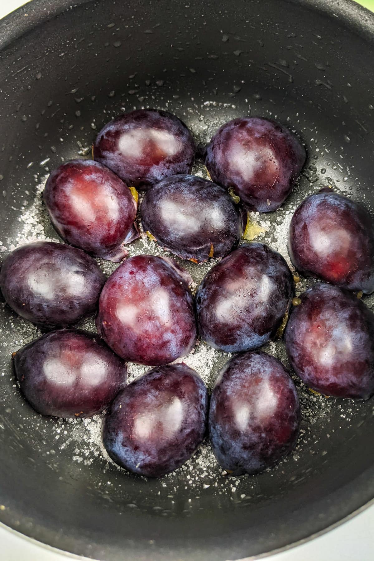 Plum halves with sugar on a baking pan.