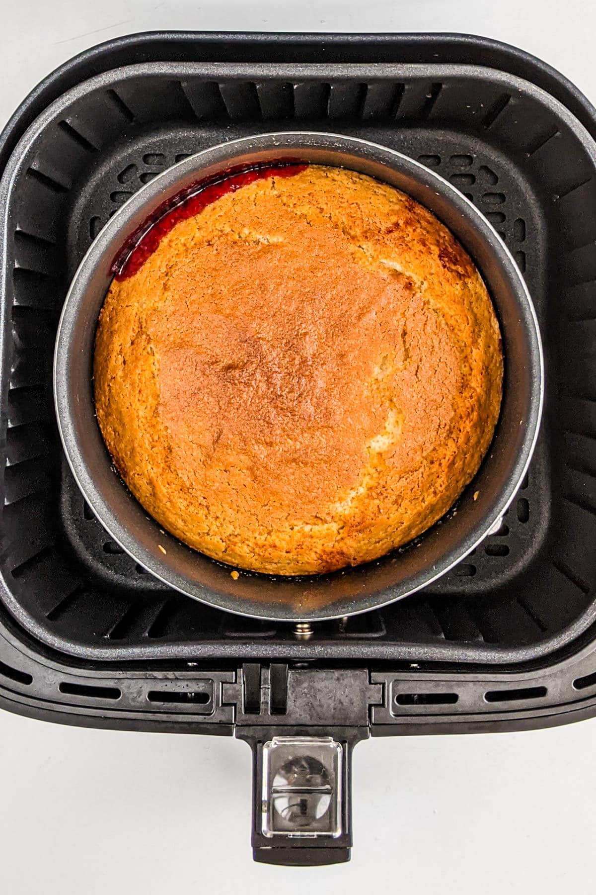 Baked plum cake in a the air fryer basket.