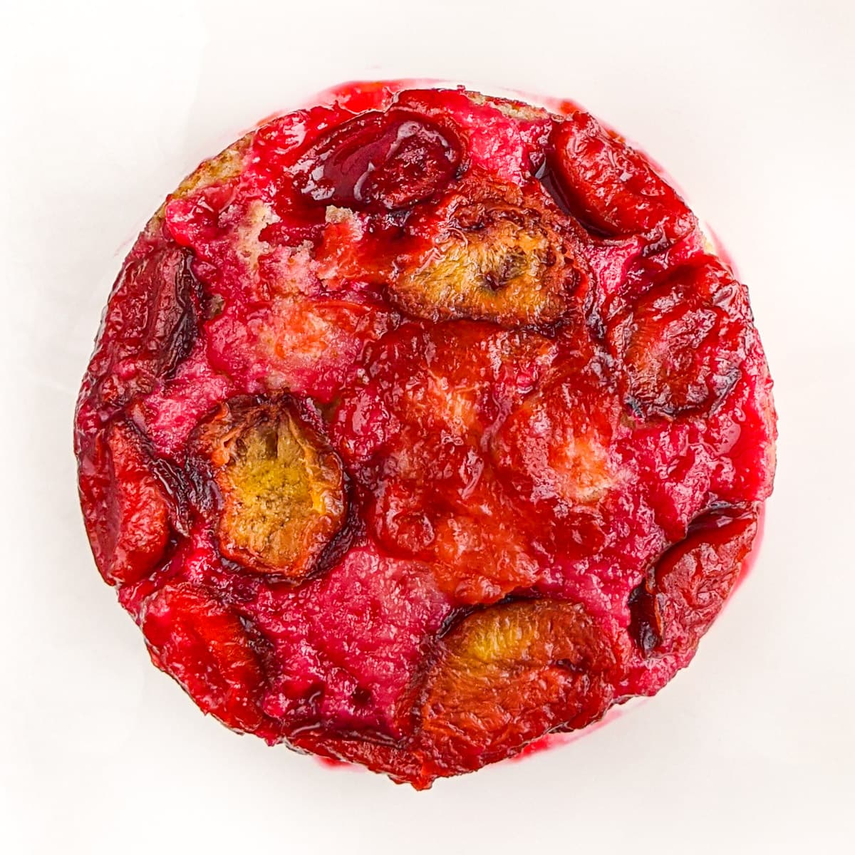 Top view of juicy plum cake on a white background.