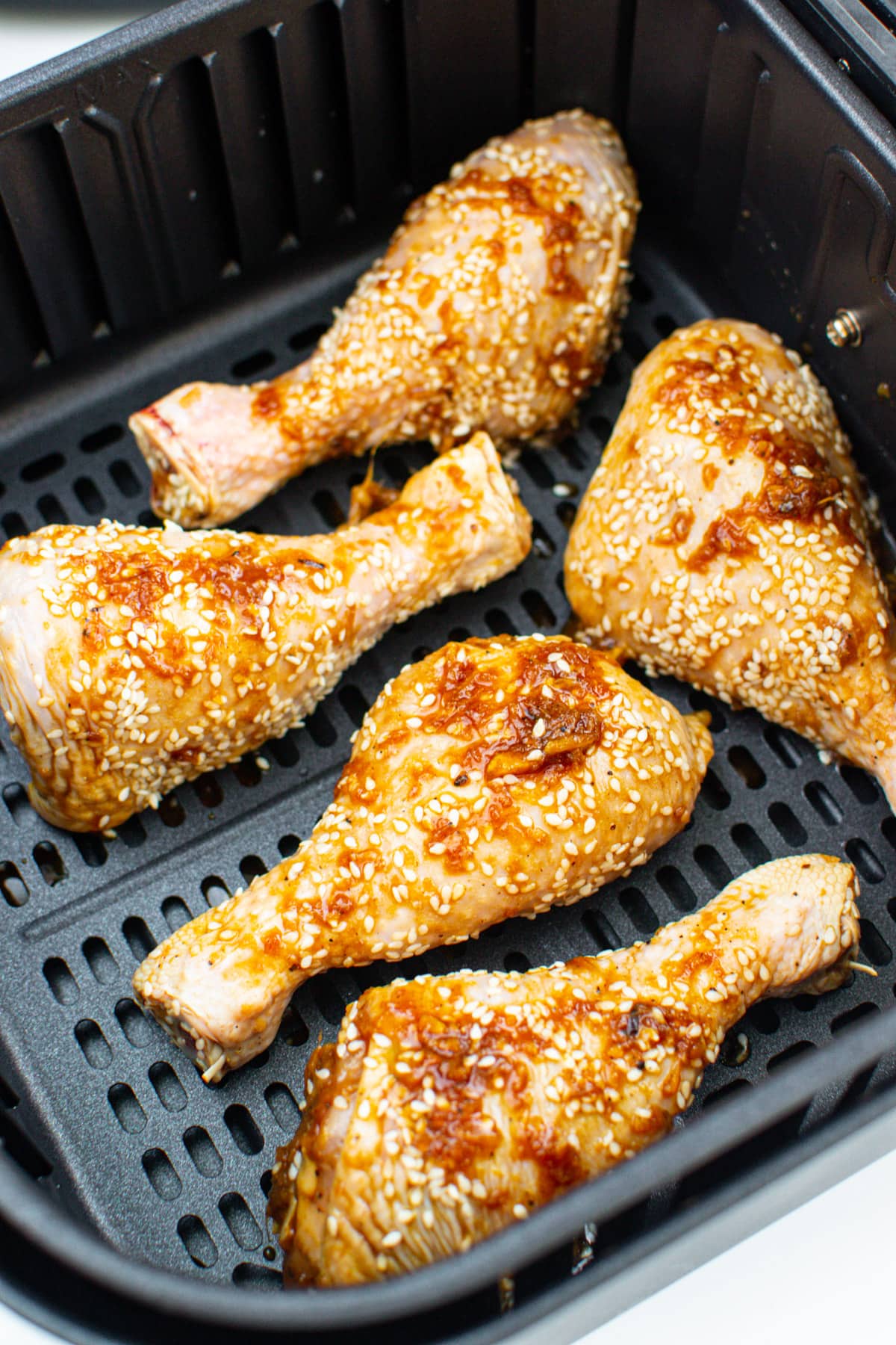 Sesame Chicken legs in an air fryer pan.