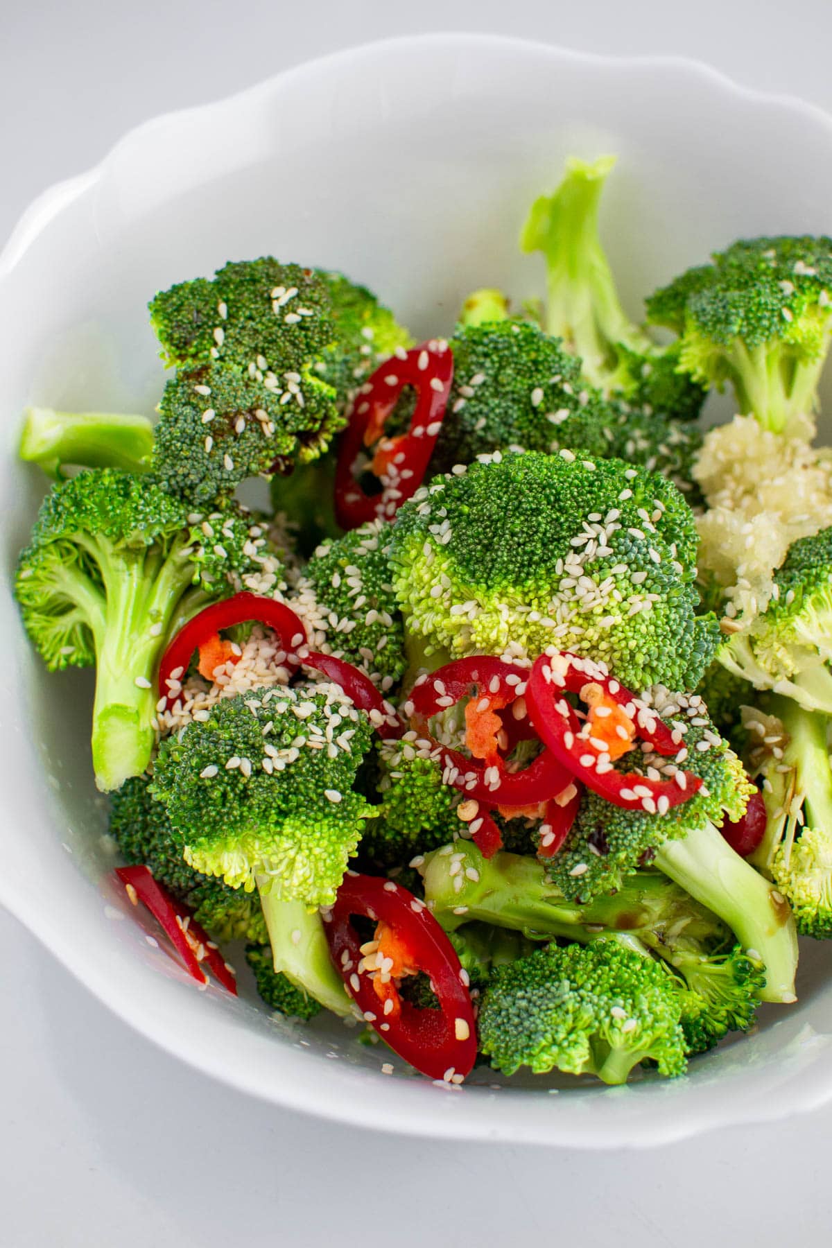 Raw broccoli with sesame seeds and red hot pepper.