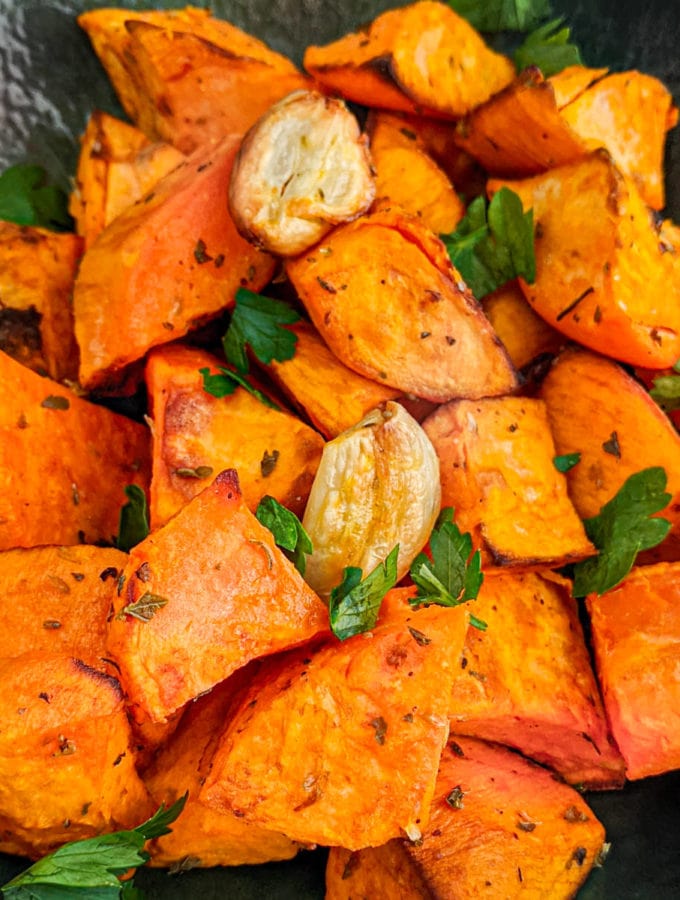Close view of the sweet potato chunks with garlic and parsley.