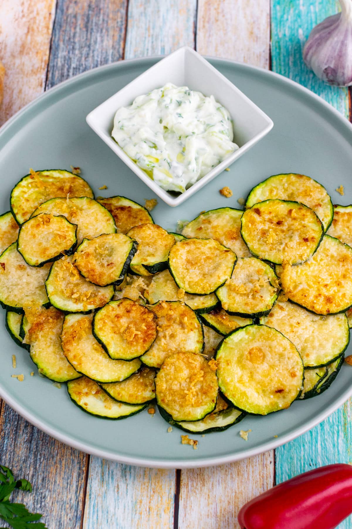 Plate with parmesan zucchini chips and tzatziki sauce.