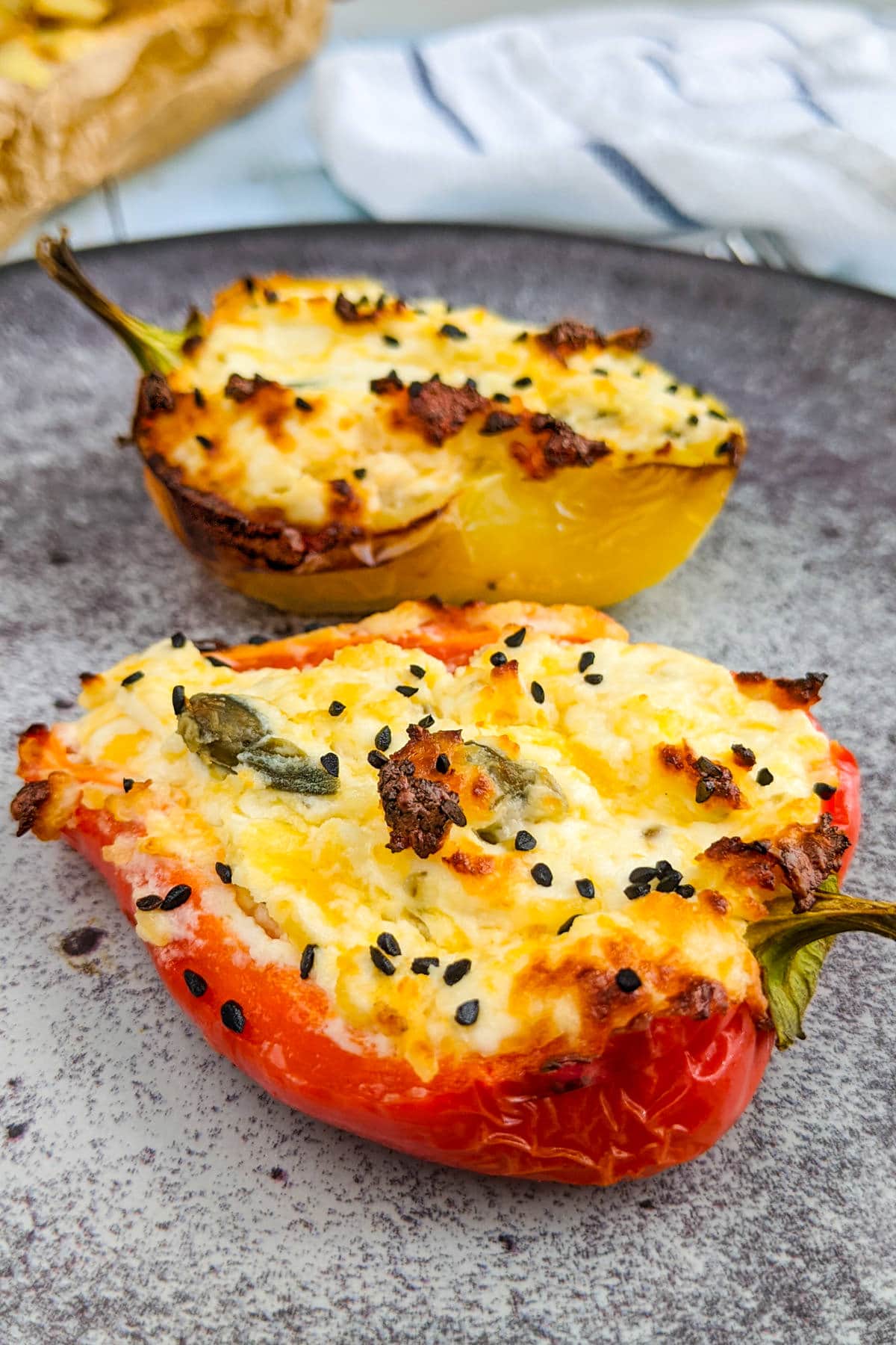 Bell pepper boats with cream cheese on a gray plate.
