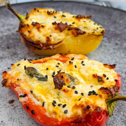 Close look at baked bell pepper stuffed with cream cheese and black cumin seeds.
