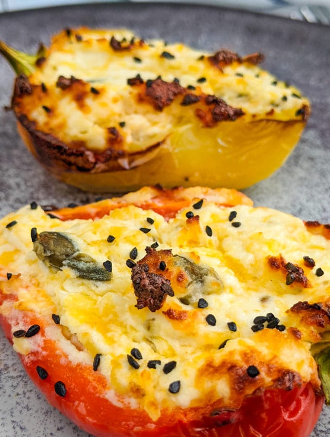 Close look at baked bell pepper stuffed with cream cheese and black cumin seeds.