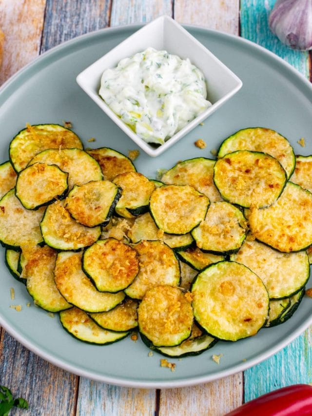 Top view of baked zucchini chips with parmesan and garlic.