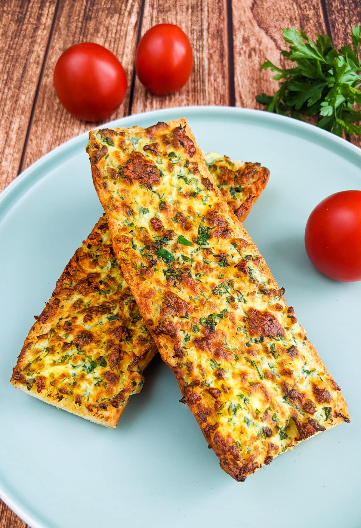 Air fryer garlic bread with tomatoes and chopped parsley.