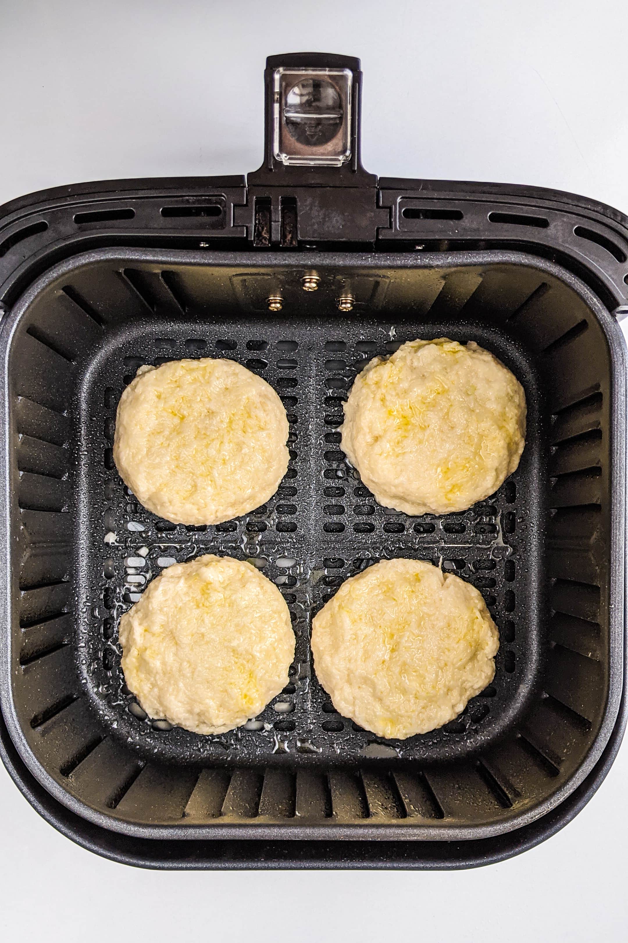 Raw hash browns in the air fryer basket.