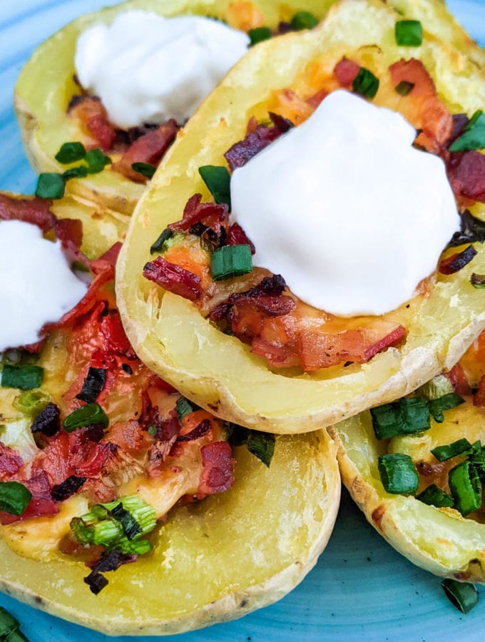 Air Fryer potato skins with sour cream on a blue plate.