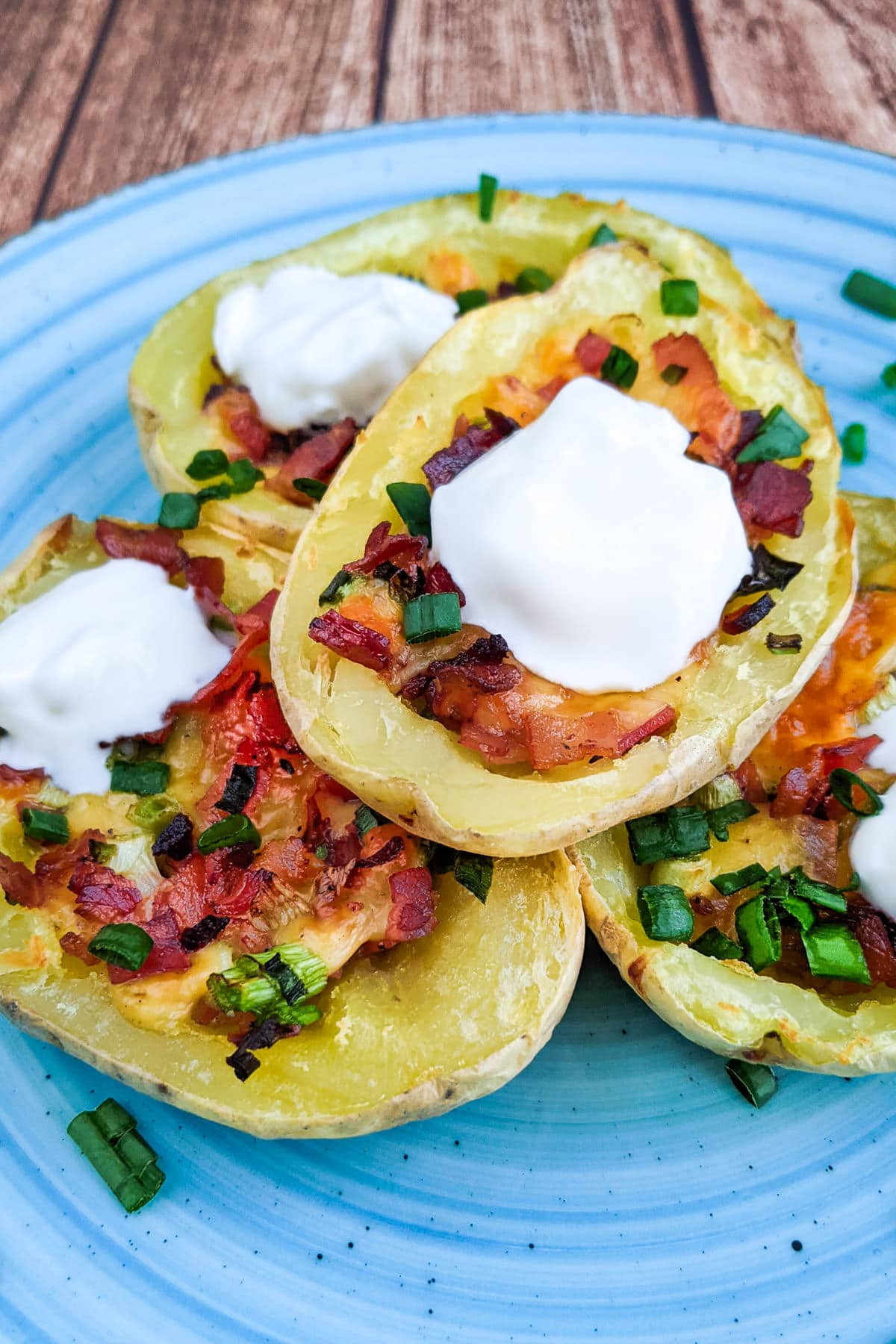 Air Fryer potato skins with sour cream on a blue plate.