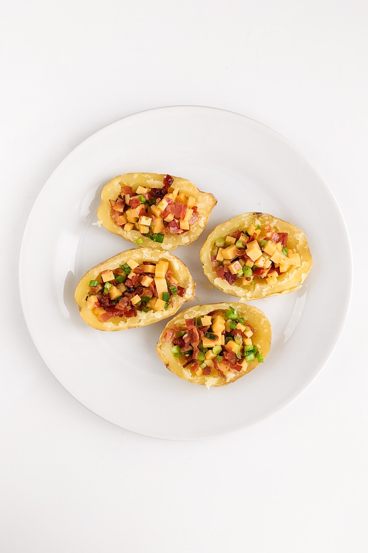 Four potato skins filled with bacon, onions and cheddar cheese.