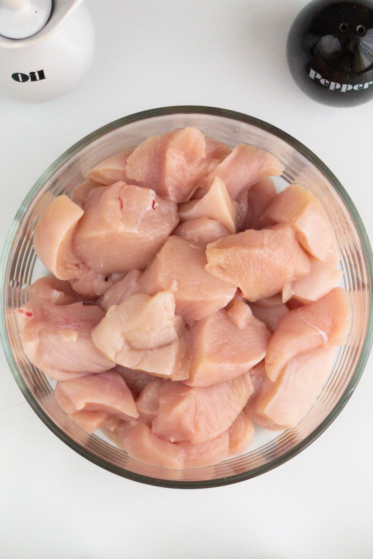 Chicken breast meat pieces in a transparent plate.