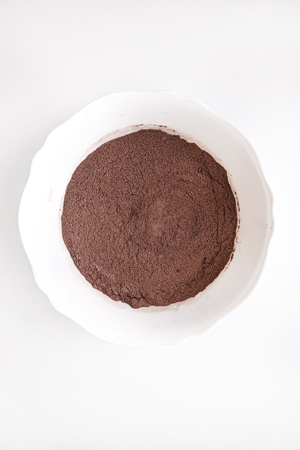White bowl with a mix of cacao, sugar and all purpose flour.