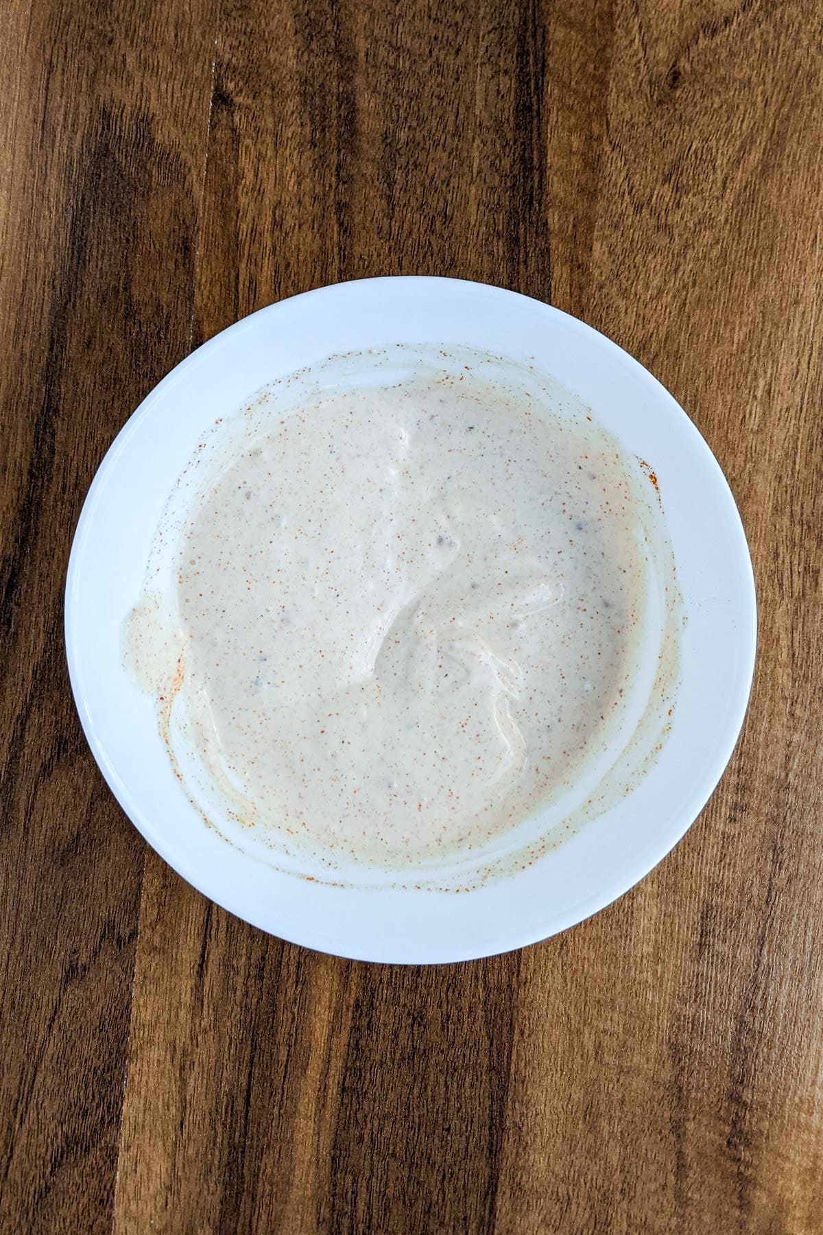 Top view of a white plate with White BBQ Alabama Sauce.