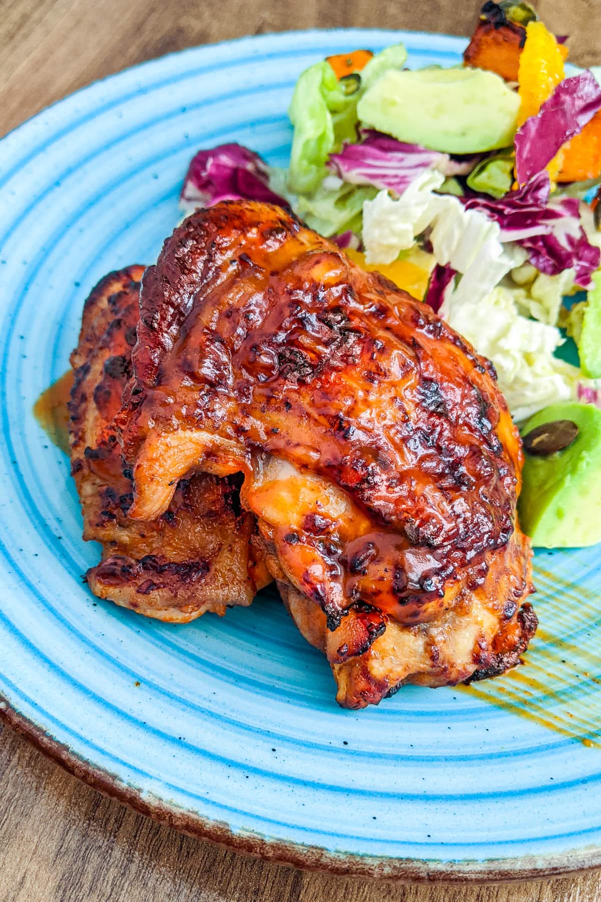 Roasted chicken thighs marinated in buffalo sauce and served with green salad.