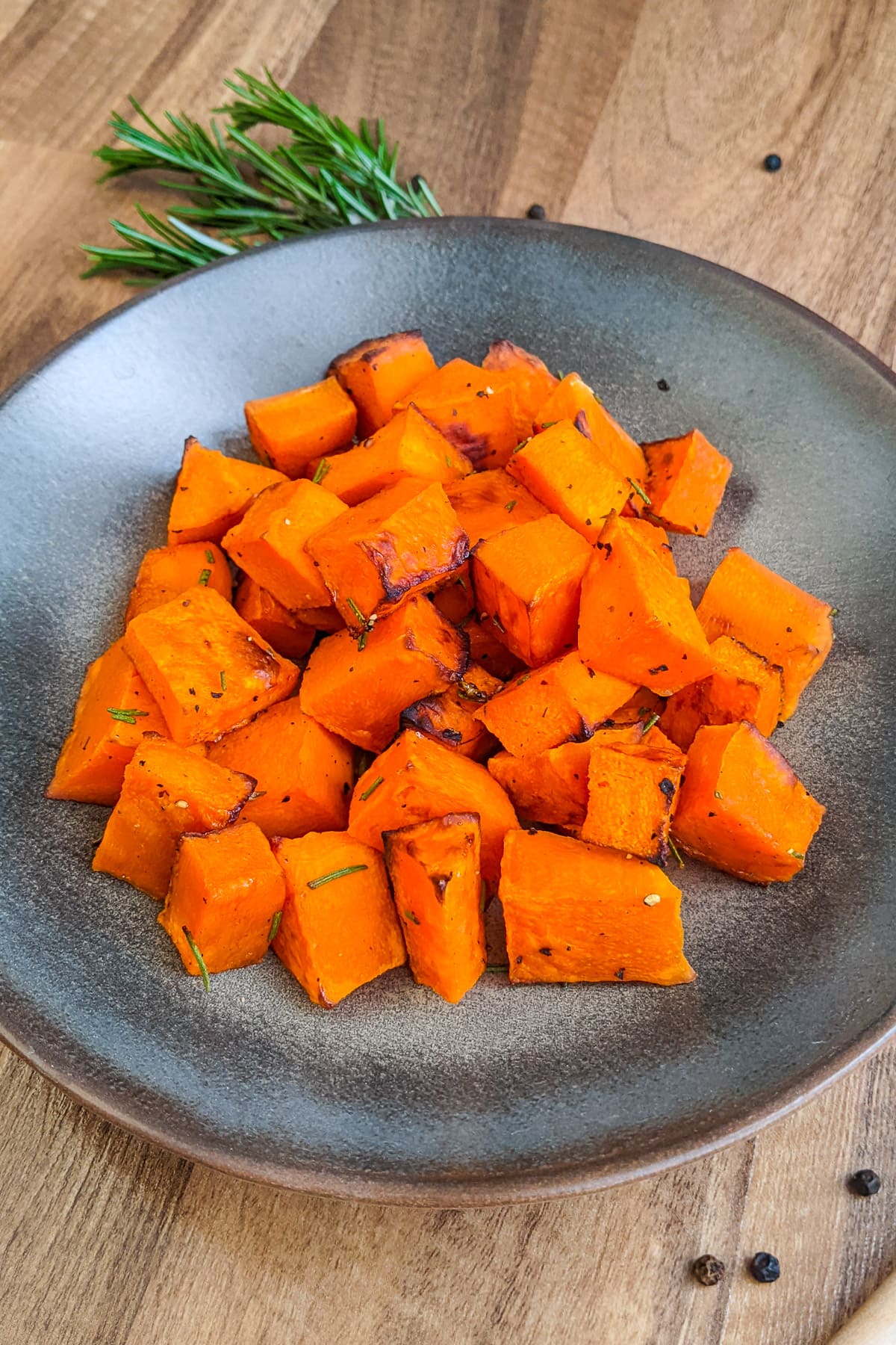A plate with butternut squash on a wooden plate.