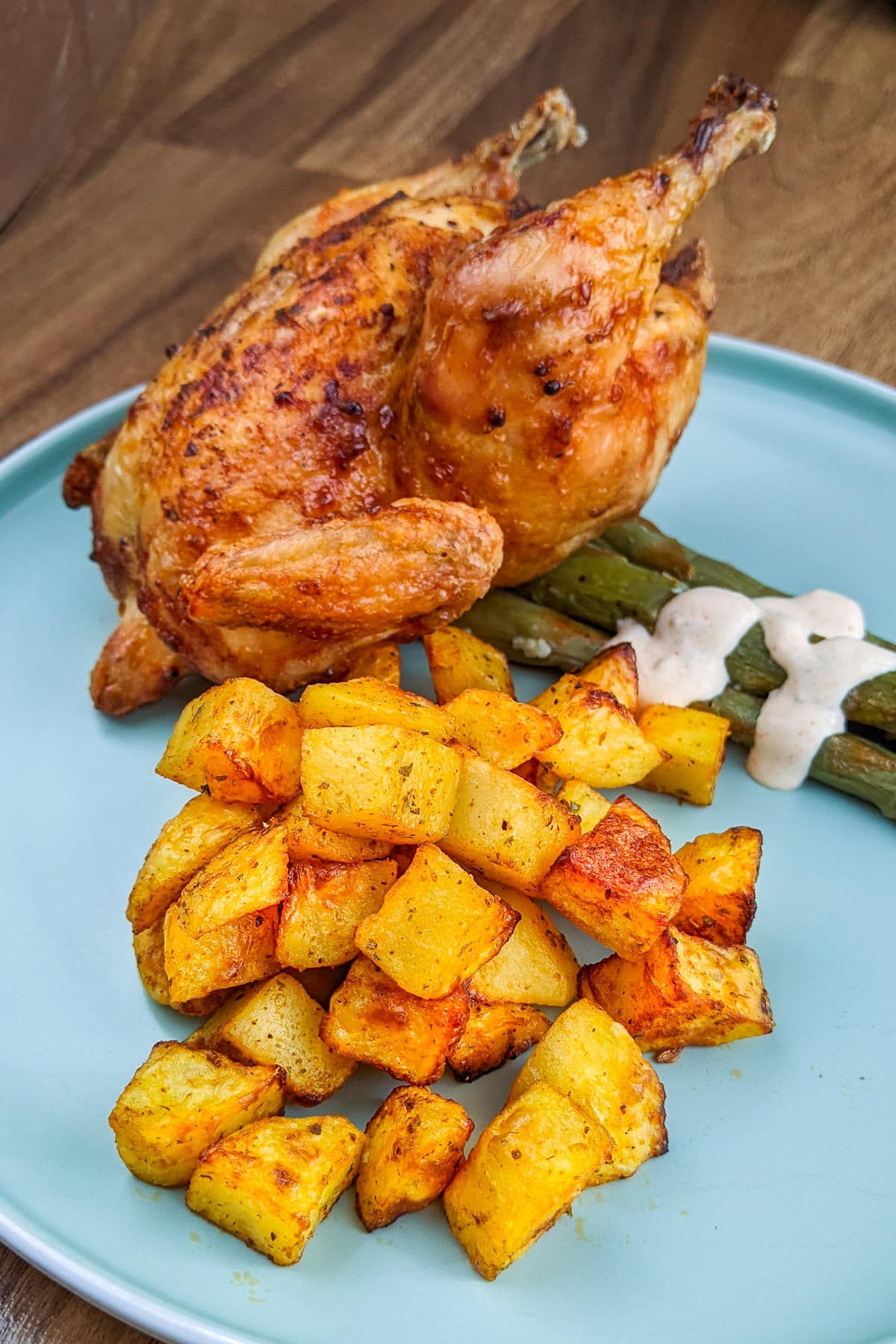 Cornish hen served with Diced potatoes and asparagus.