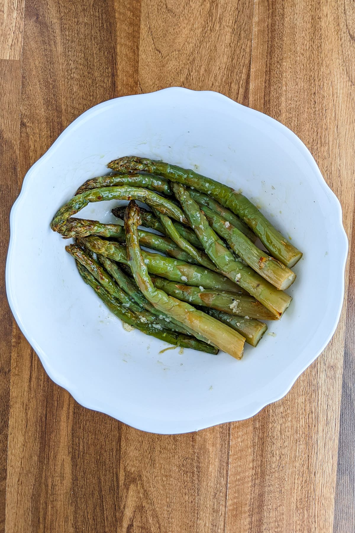 Frozen asparagus seasoned in a white plate.