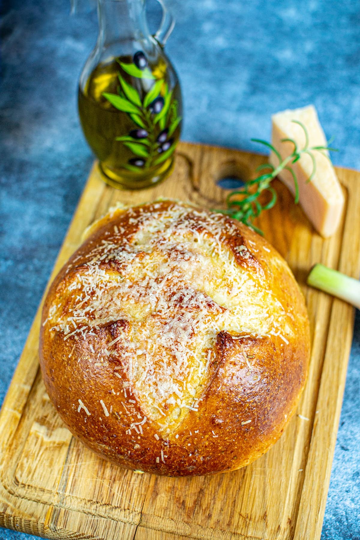 Rustic homemade Parmesan Bread on a wooden cutting board.