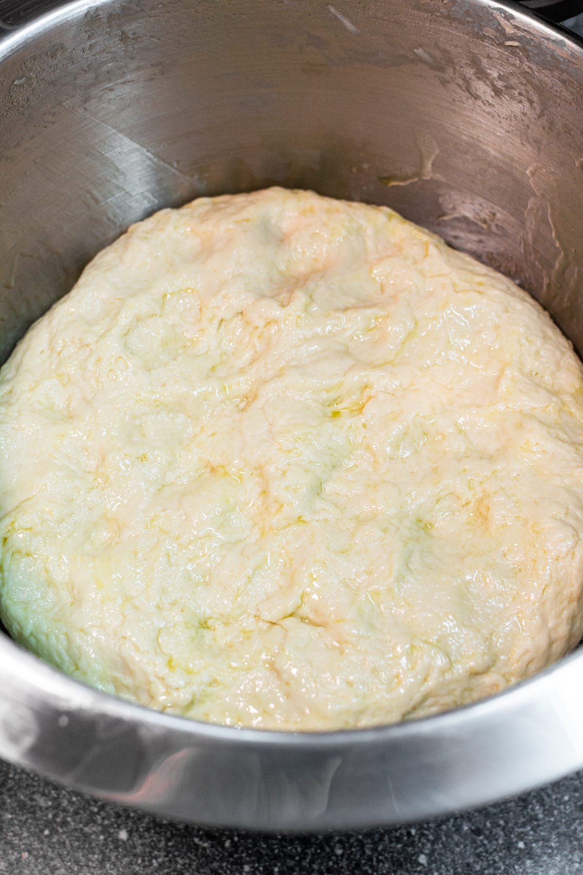 Kneaded dough in a metal bowl.