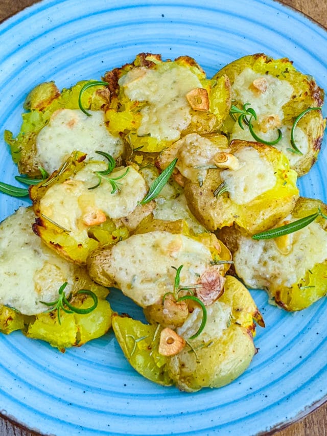 Garlicky Smashed Baby Potatoes in air fryer served on a blue plate.