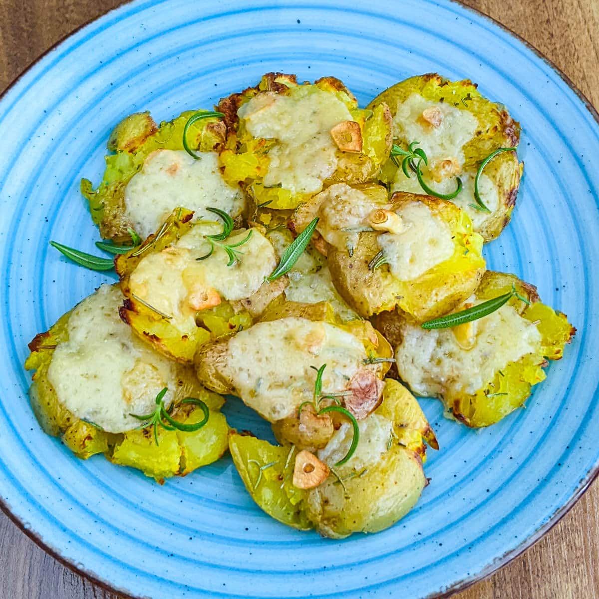 Garlicky Smashed Baby Potatoes in air fryer served on a blue plate.