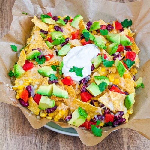 Close look of a plate with air fryer nachos loaded with cheese.
