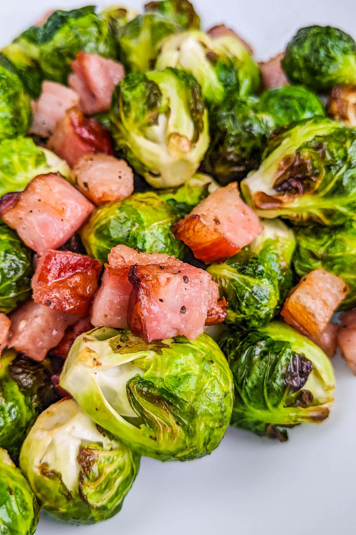 A plate with brussels sprouts with bacon cooked in air fryer.